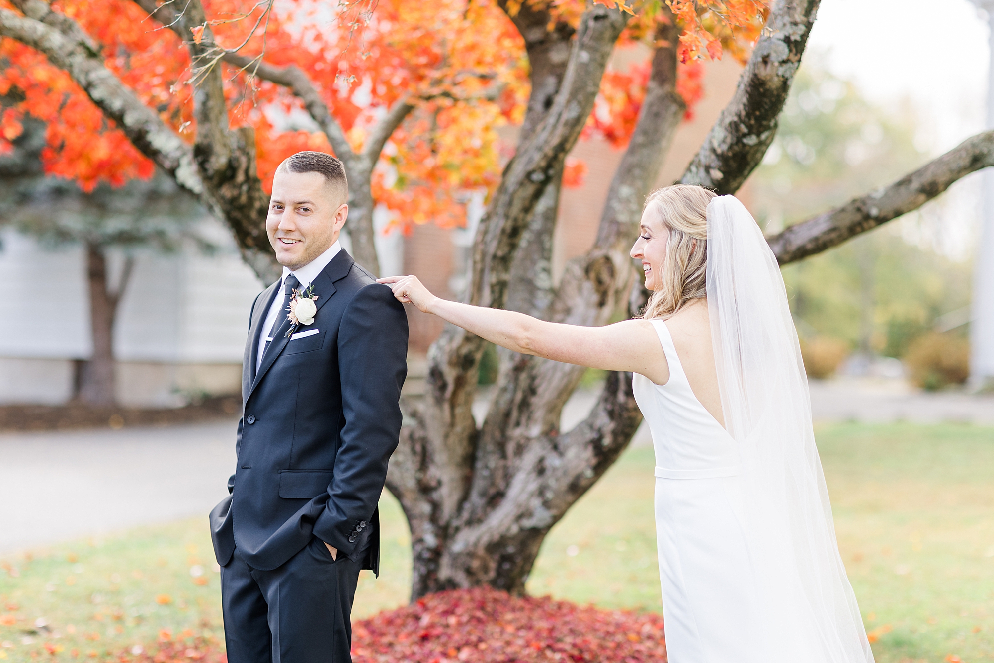 first look between bride and groom under fall tree
