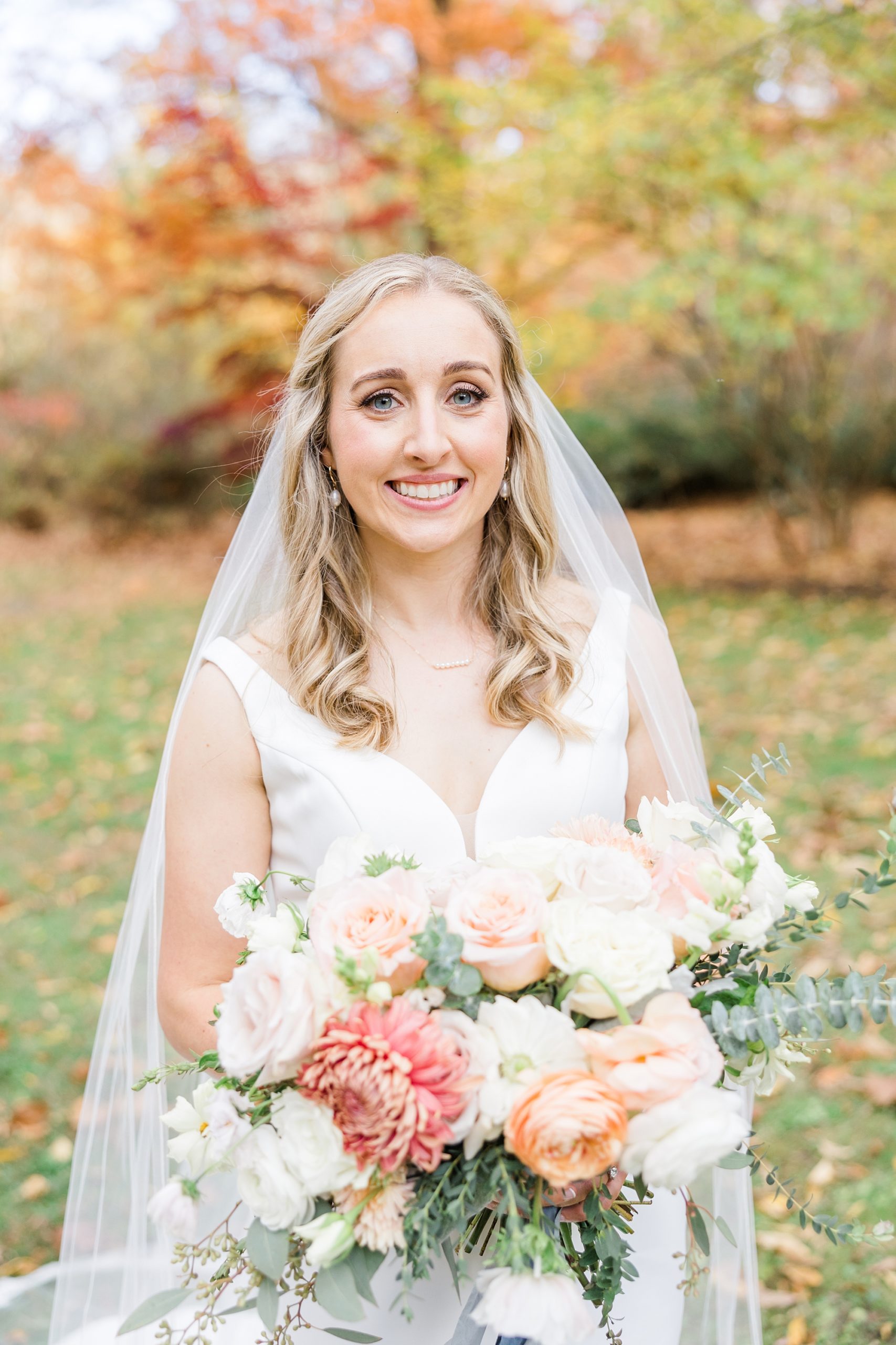 bride holding light colored wedding bouquet