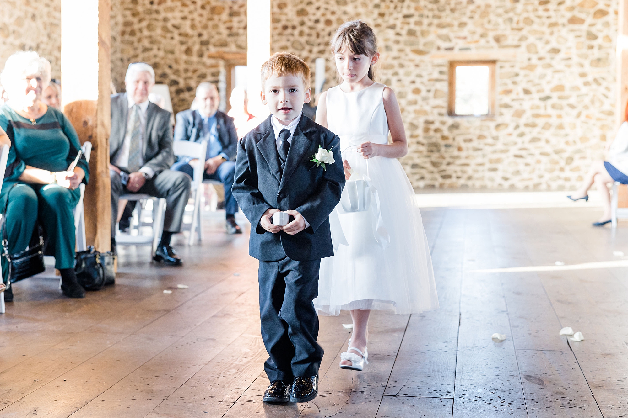 flower girl and ring bearer walking down aisle at wedding ceremony