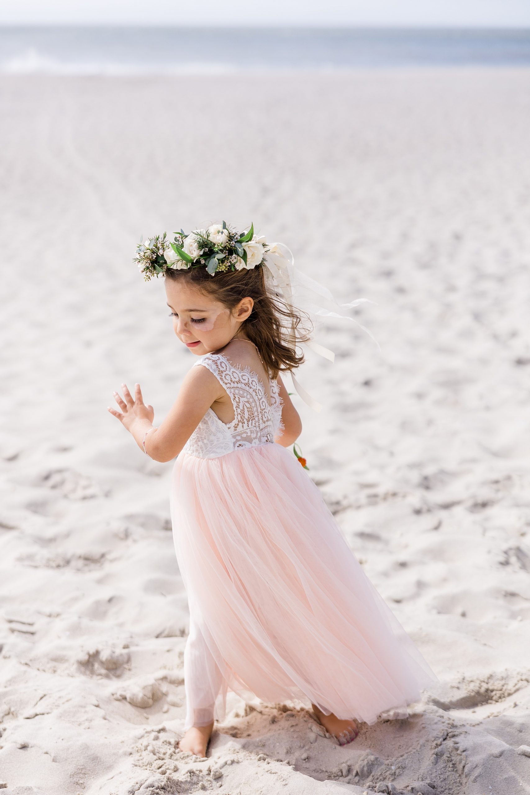 bride's daughter plays on the beach 