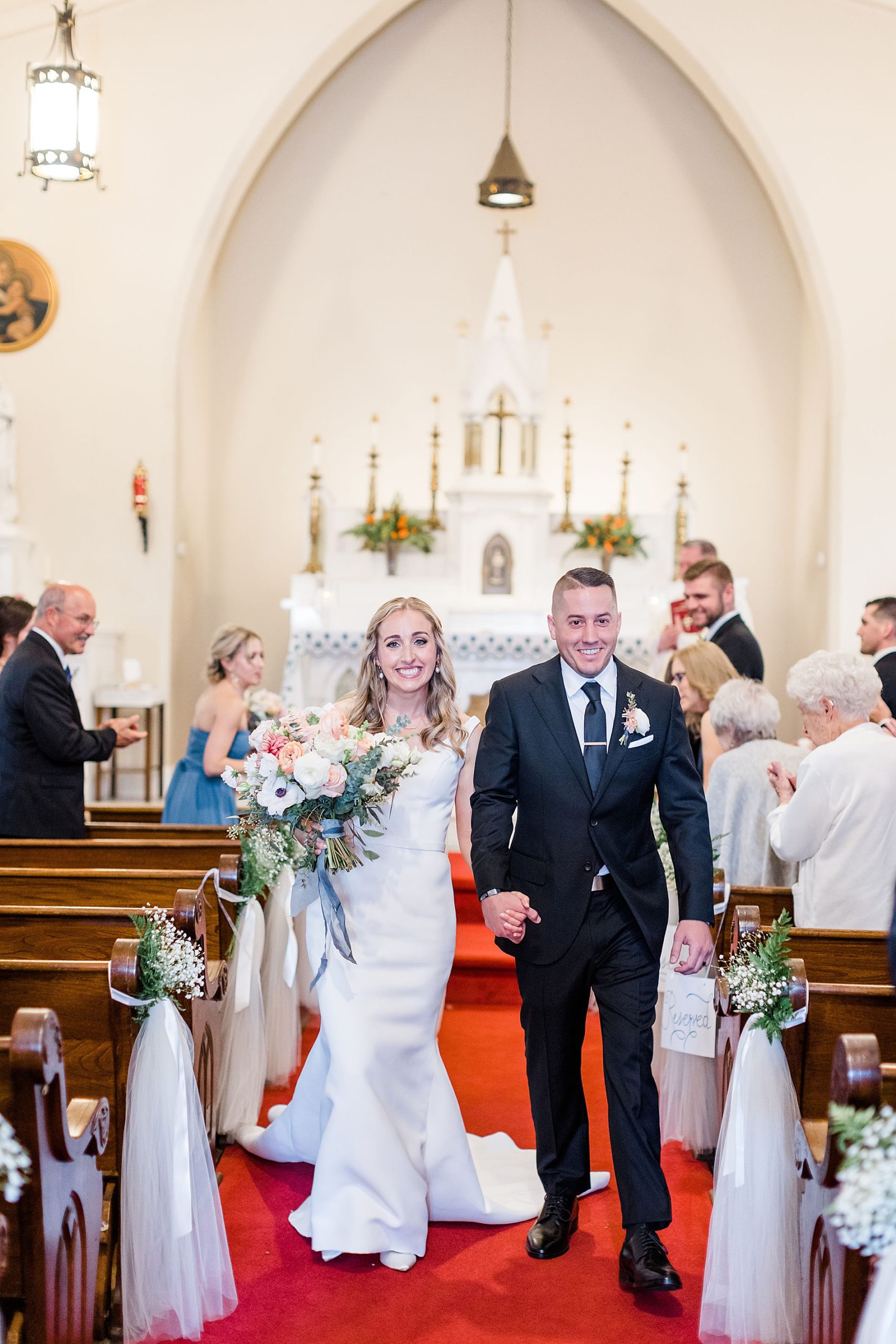 newlyweds smile as they as exit the church