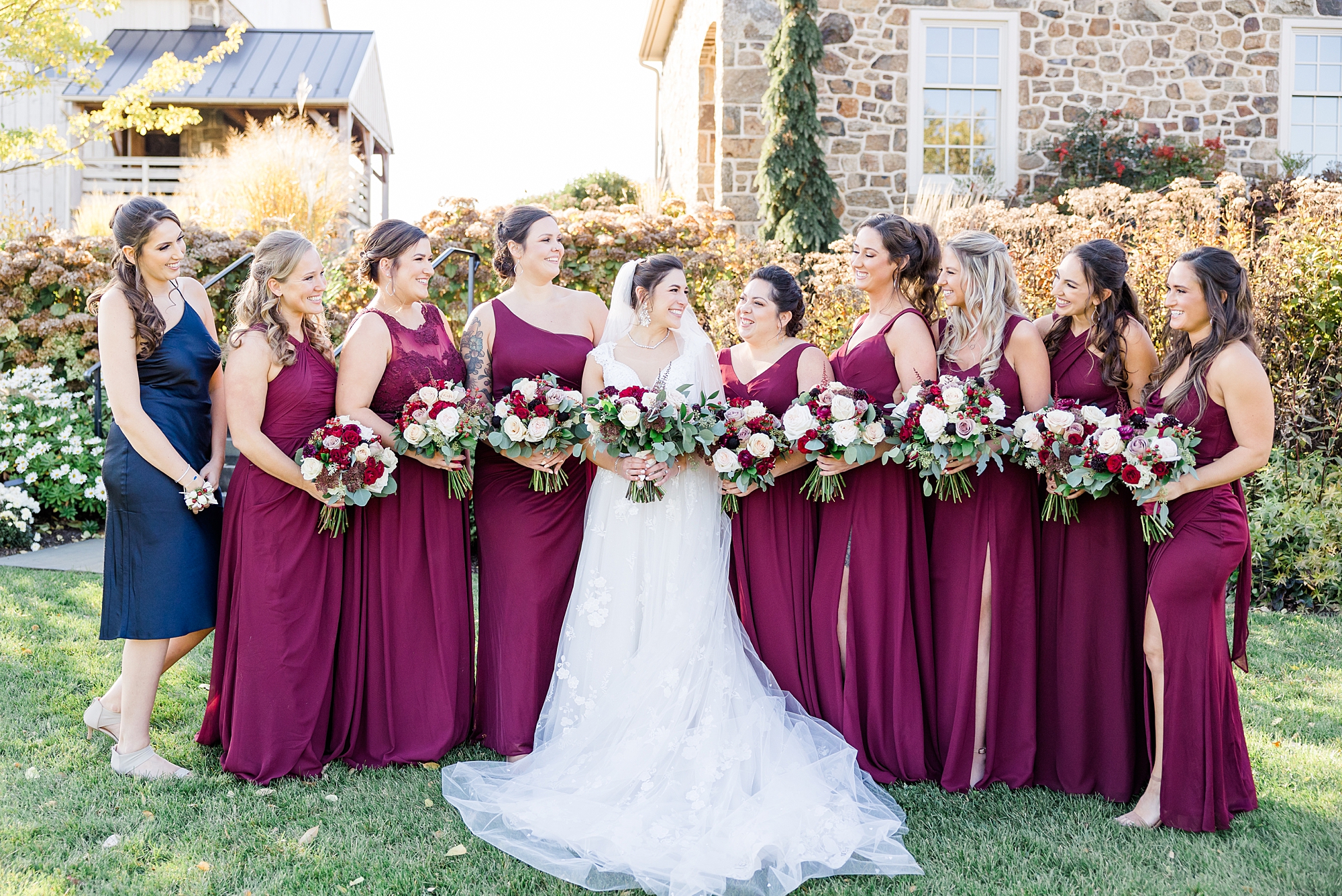 bridesmaids in cabernet dresses surround bride