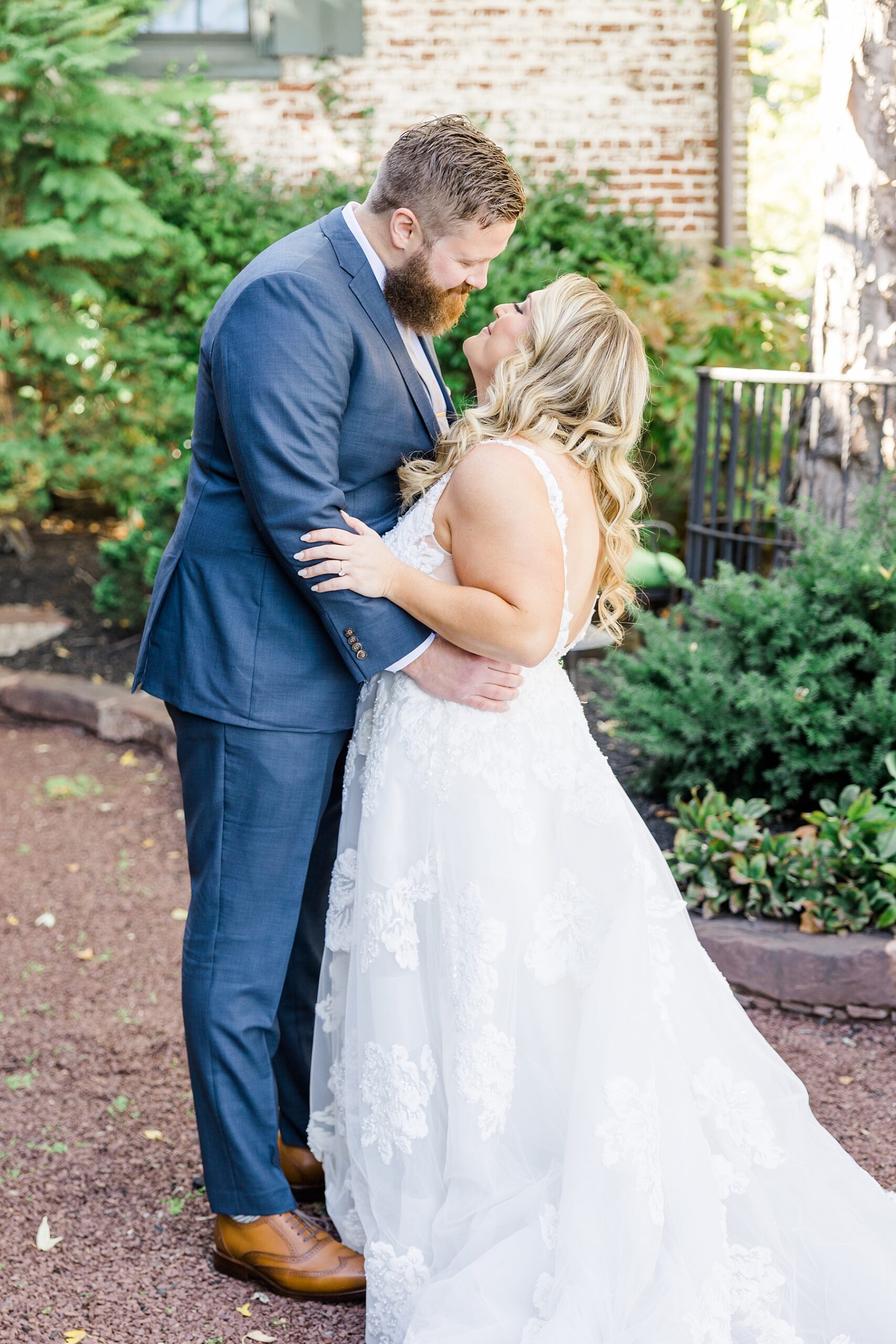 couple lean in for a kiss during wedding portraits 