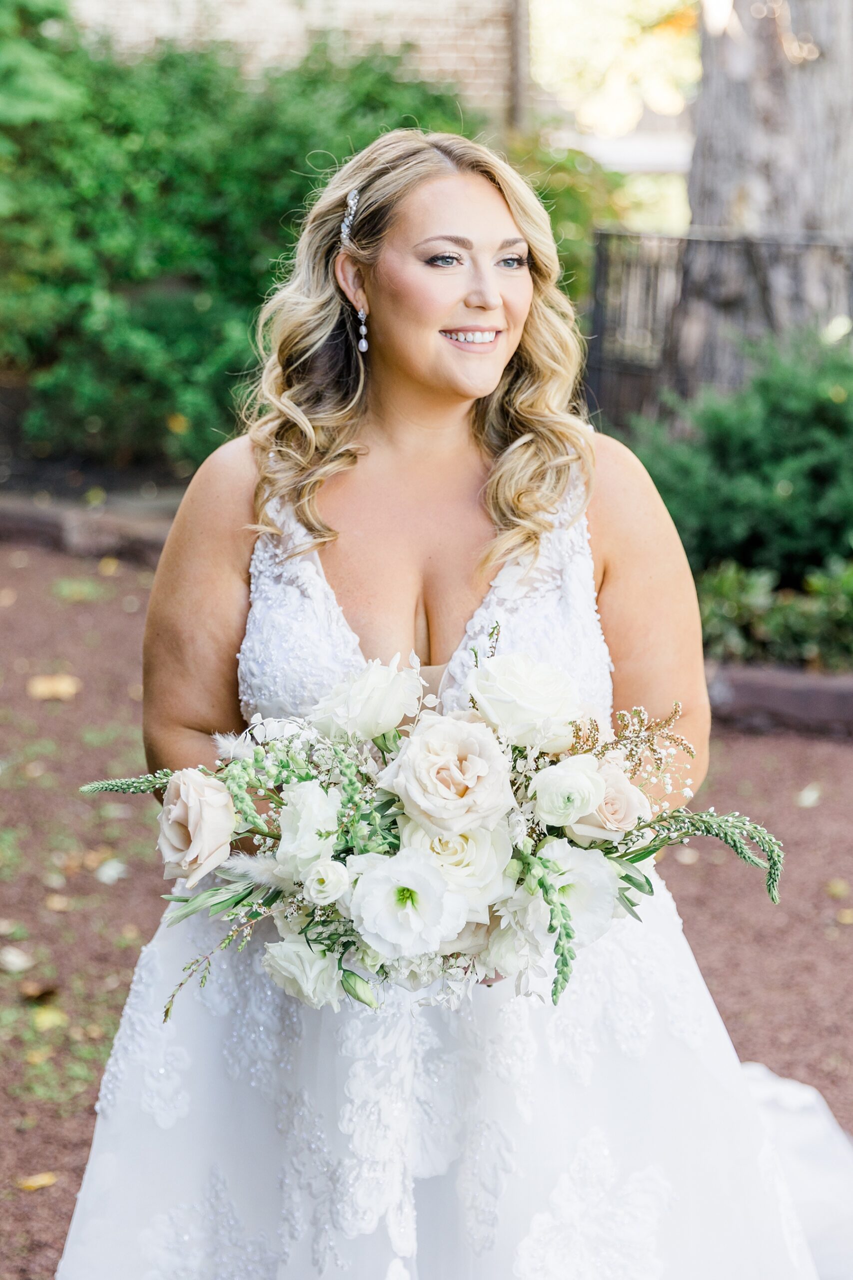 bridal portraits holding an elegant bouquet of white and taupue flowers