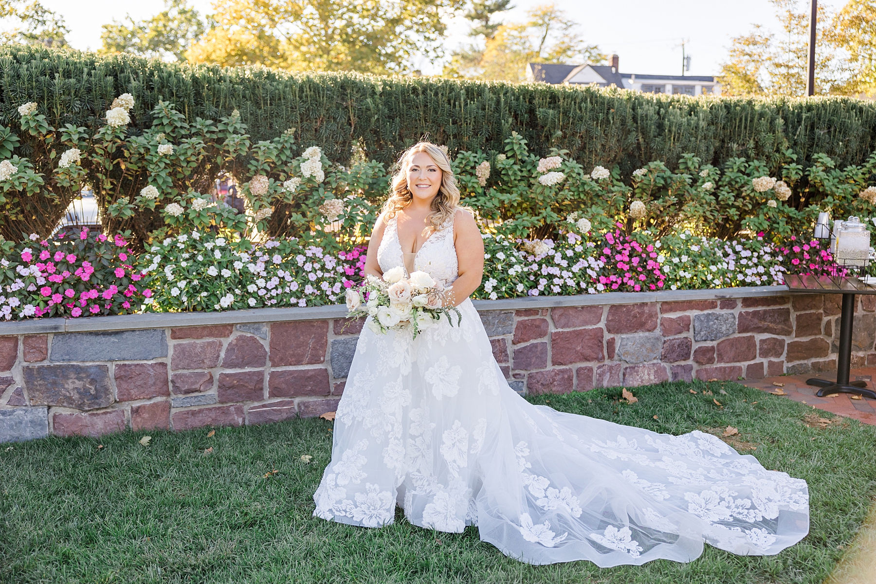 bride portraits near stone wall with flowers at Stella of New Hope Wedding