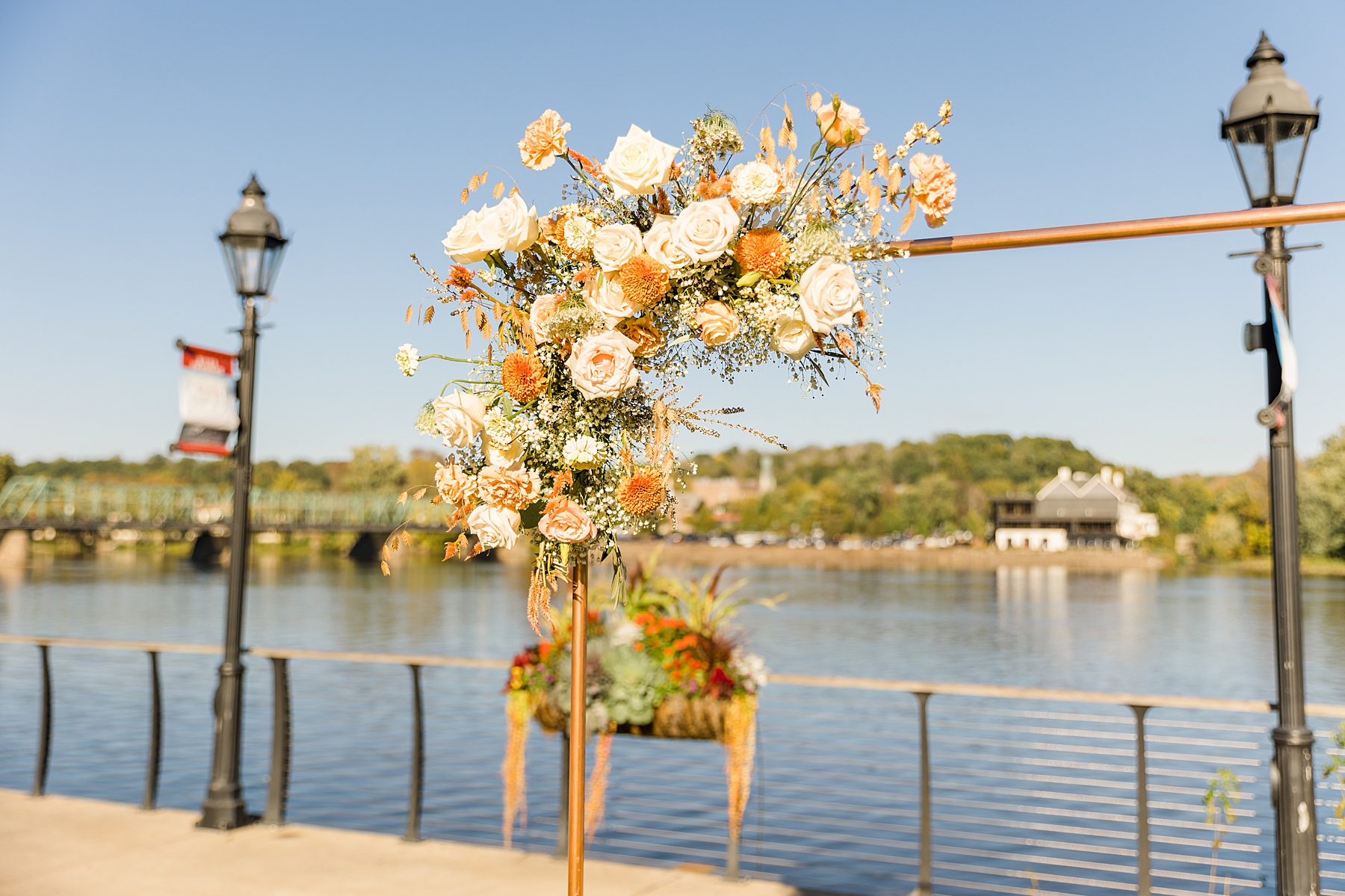 wedding arch decorated with white and rust colored flowers 