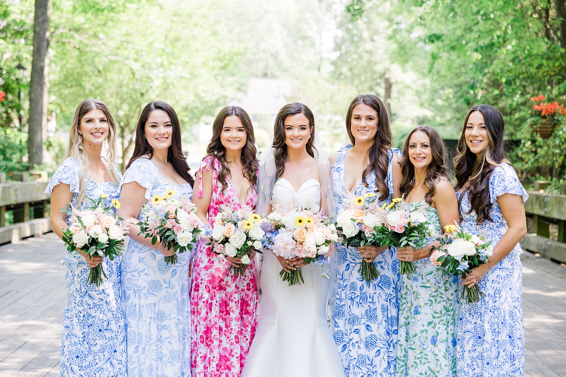 bride and bridesmaids in different floral dresses