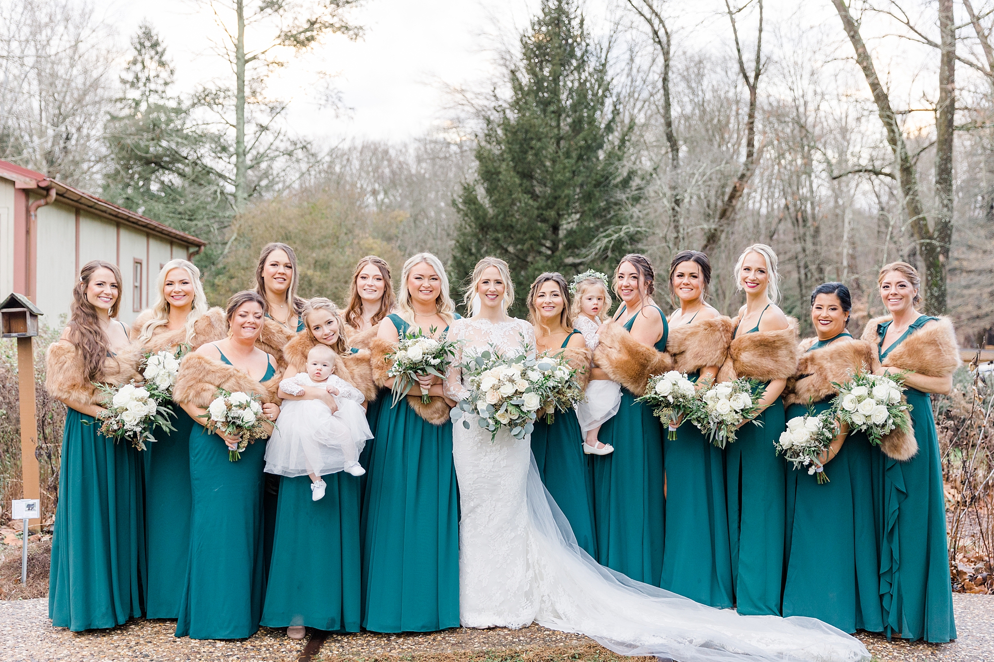 bridesmaids wear fur shaw during outside wedding portraits