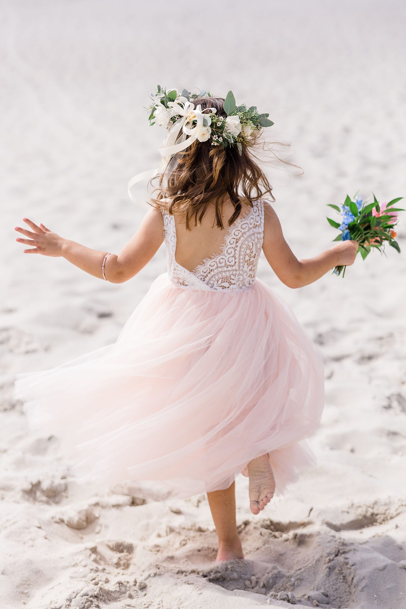 flower girl runs along the beach