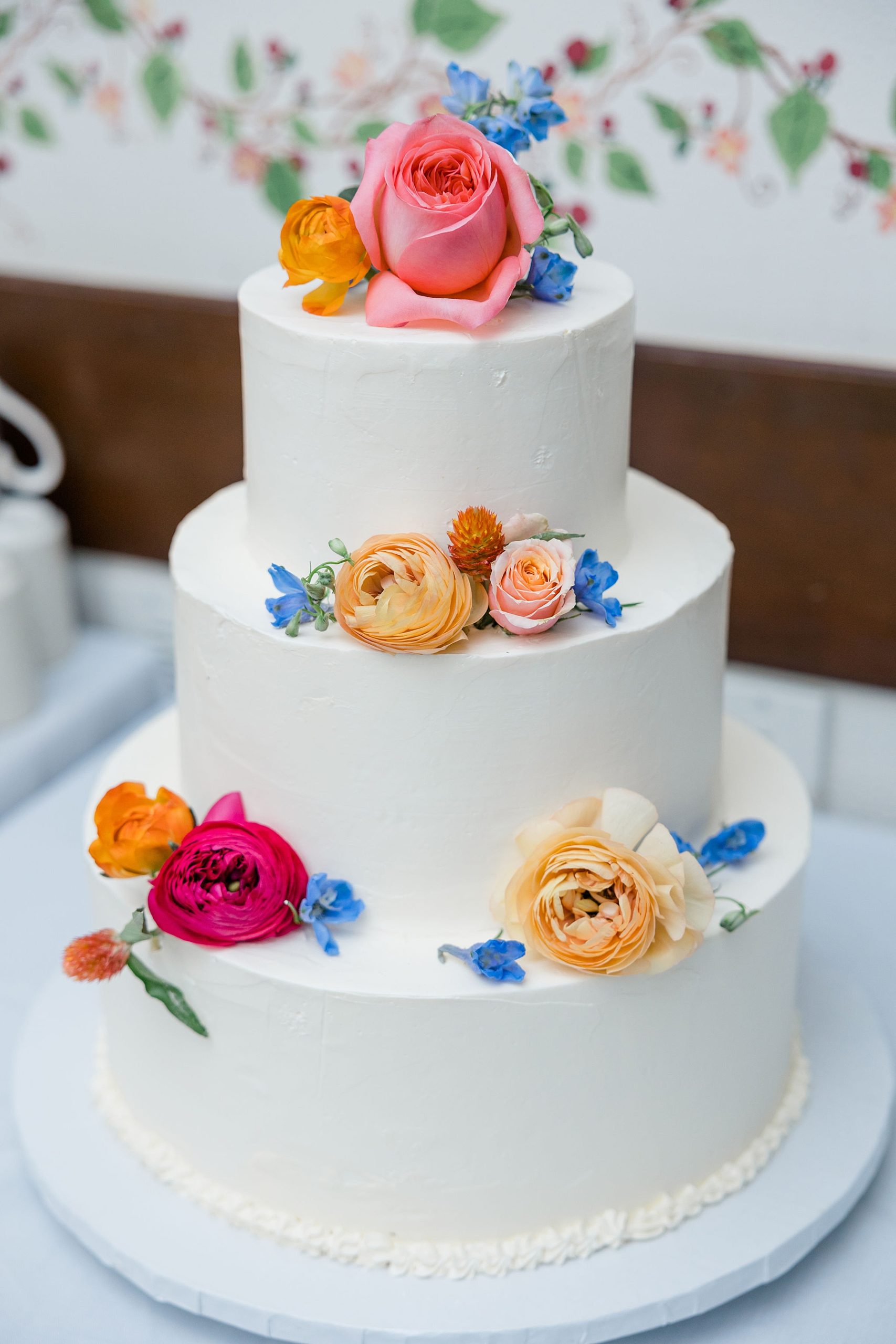 classic three tier wedding cake with vibrant flowers