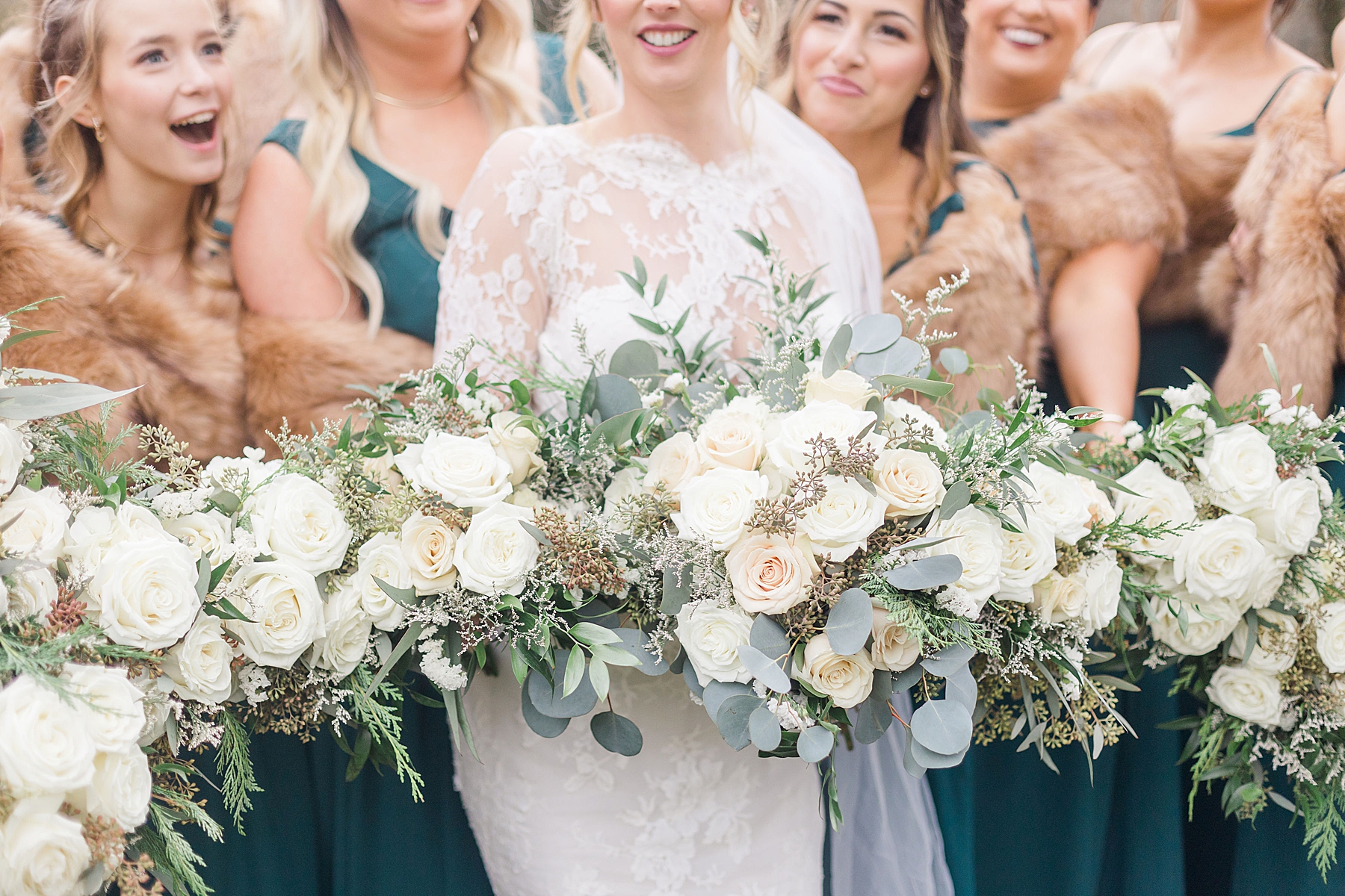 bride and bridesmaids holding white wedding bouquets
