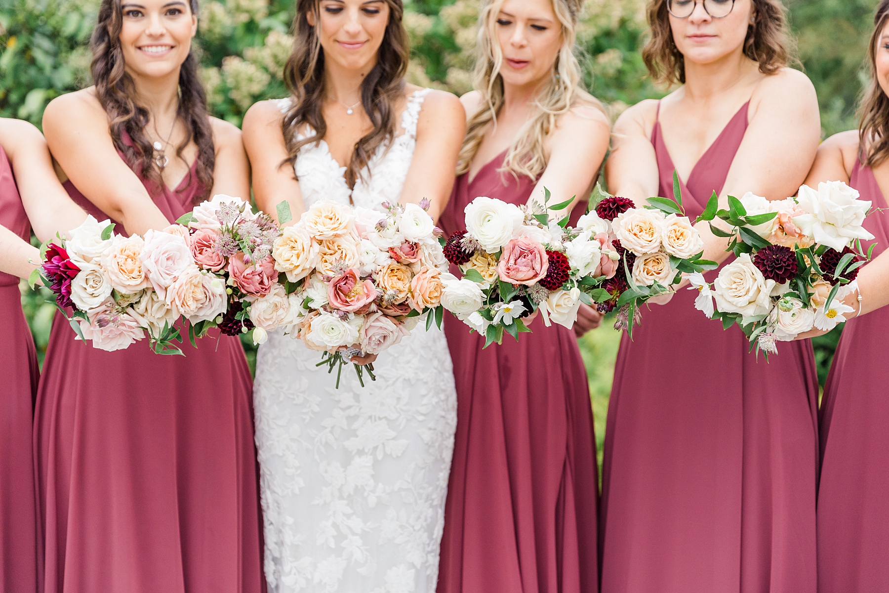 bride and bridesmaids hold out their romantic wedding bouquets 
