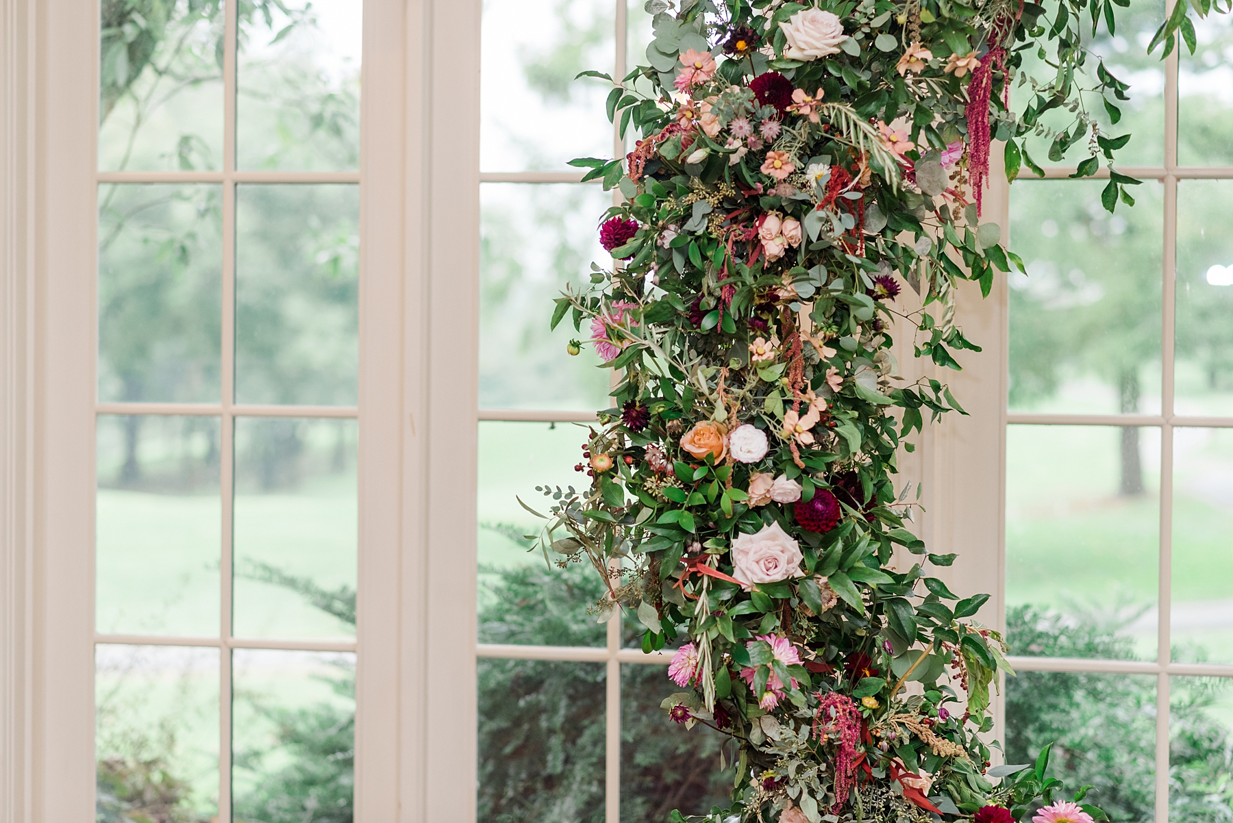 flowers and lush greenery decorating circular wedding arch at wedding ceremony