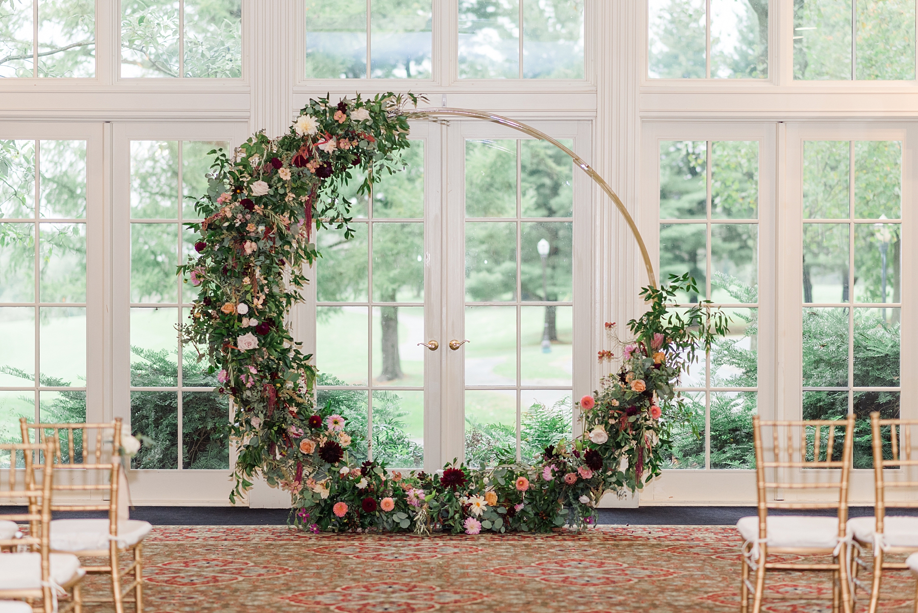 circular wedding arch decorated with flowers and greenery