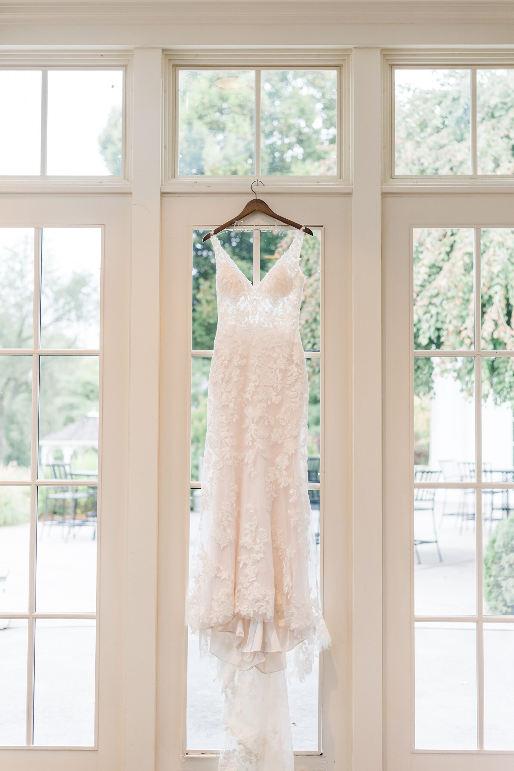 wedding dress hanging from window 