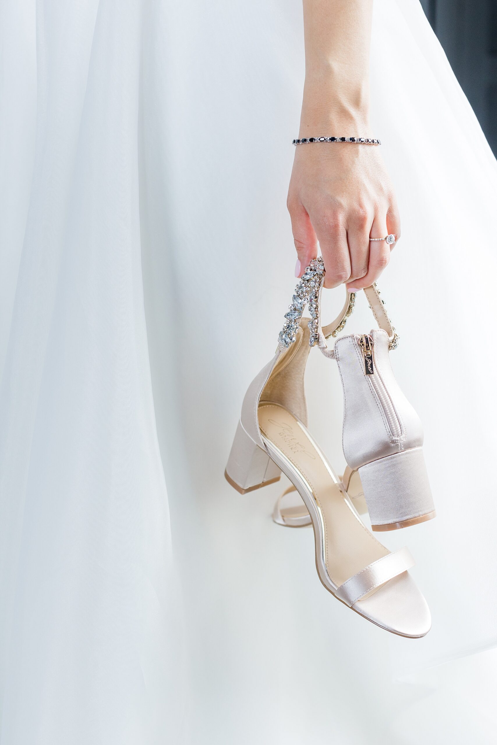 bride holds her wedding shoes