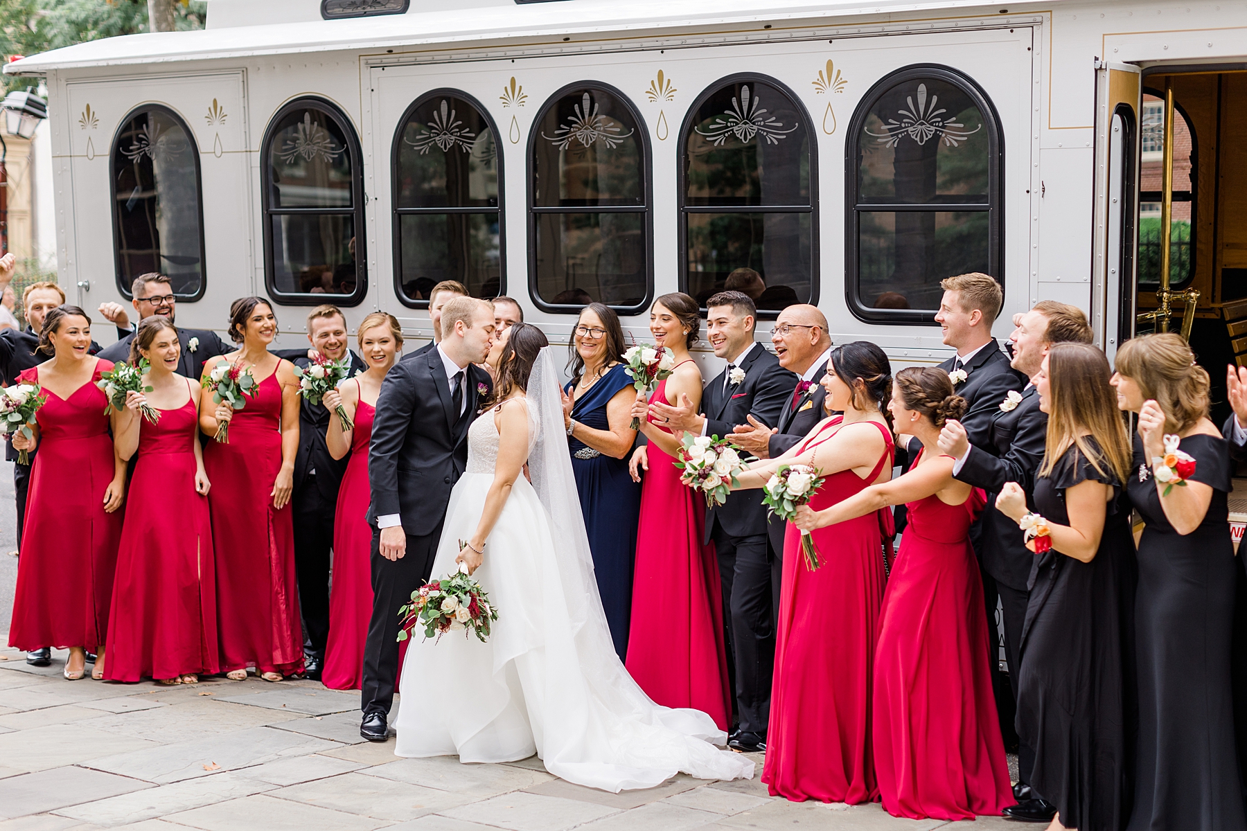 wedding party cheers as couple kiss