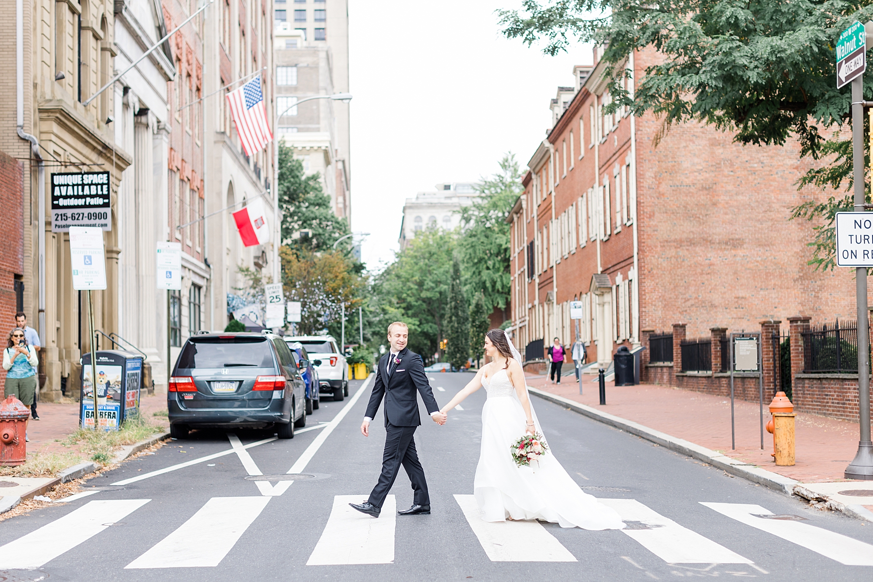 bride and groom cross the street in downtown Philadelphia 