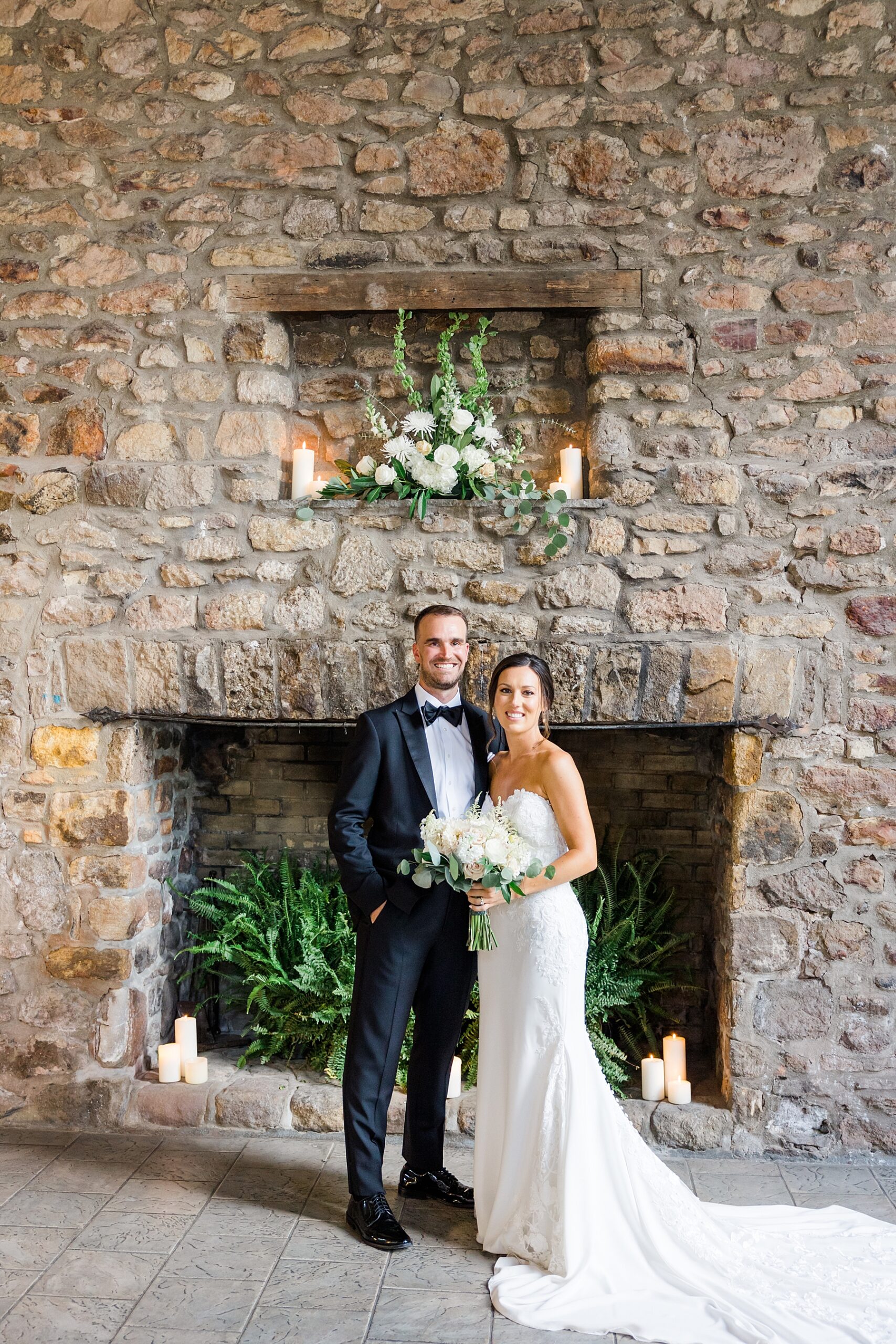 couple stand by stone fireplace at Elegant HollyHedge Estate Wedding