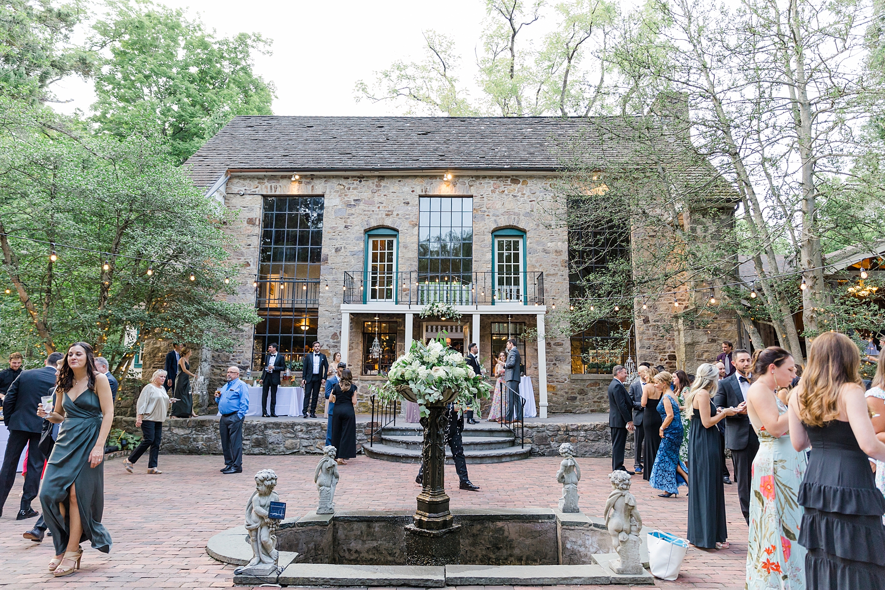 wedding guests mingle in the courtyard during cocktail hour